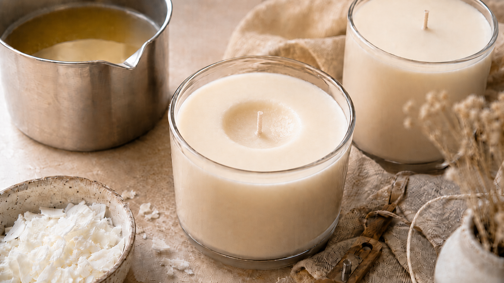 Bougies avec un pichet de cire fondue et des copeaux de cire