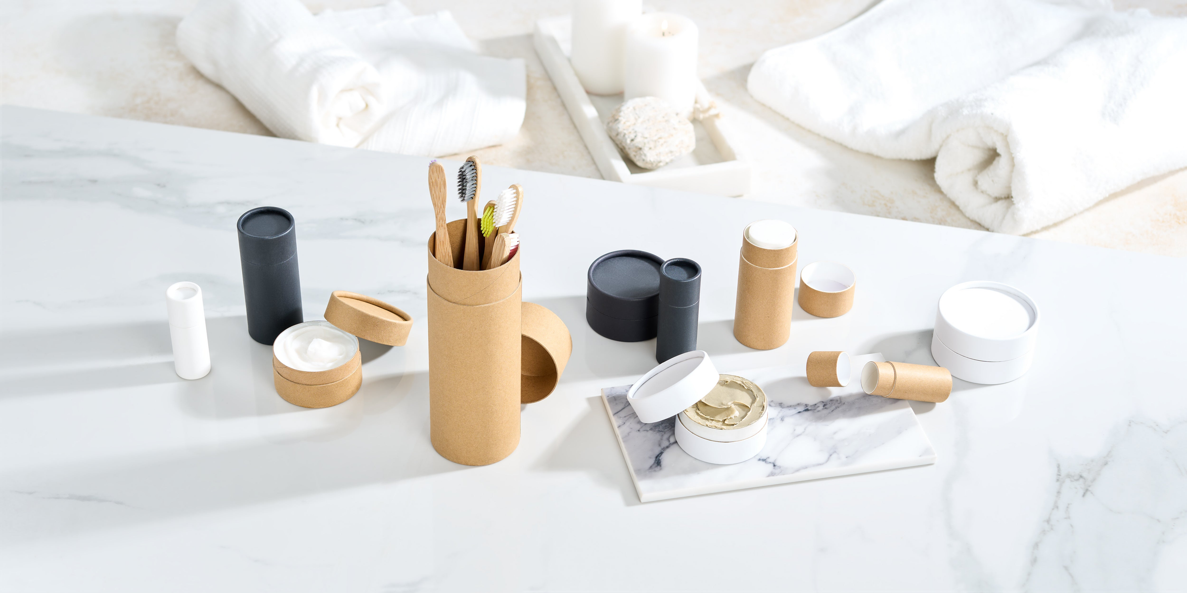 Trois tubes en carton de couleurs différentes en noir, blanc et kraft dans un salon avec des diffuseurs à l'intérieur.