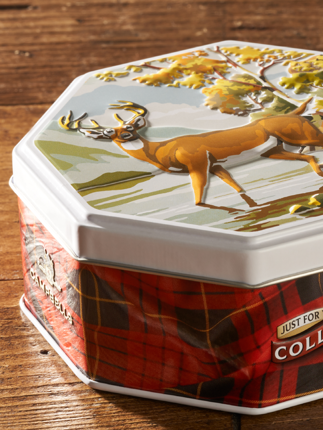 Une boîte métallique personnalisée d'un cerf dans une forêt avec un relief 3D sur le couvercle.