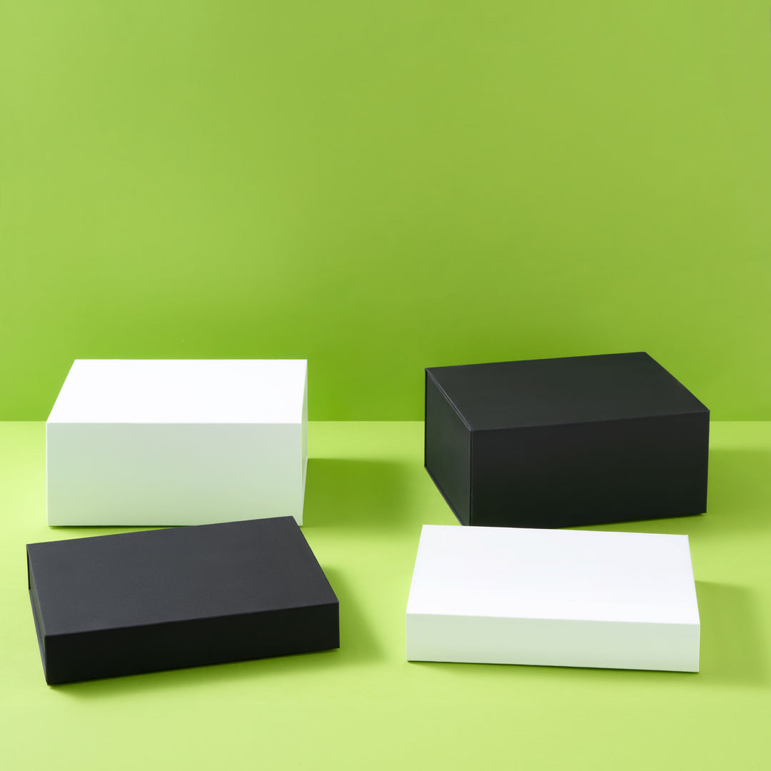Collection de coffrets cadeaux en noir et blanc sur fond vert
