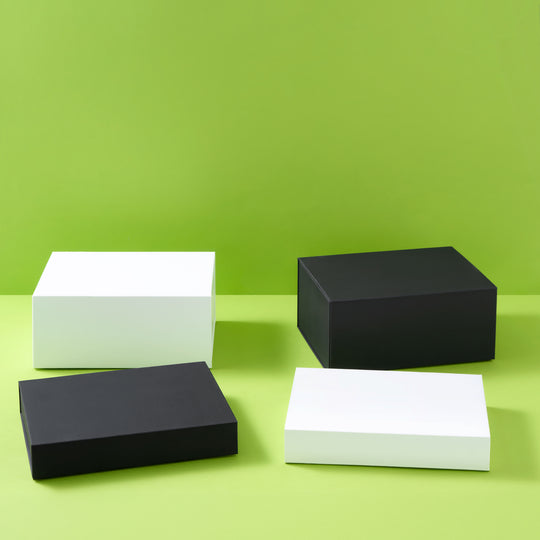 Collection de coffrets cadeaux en noir et blanc sur fond vert
